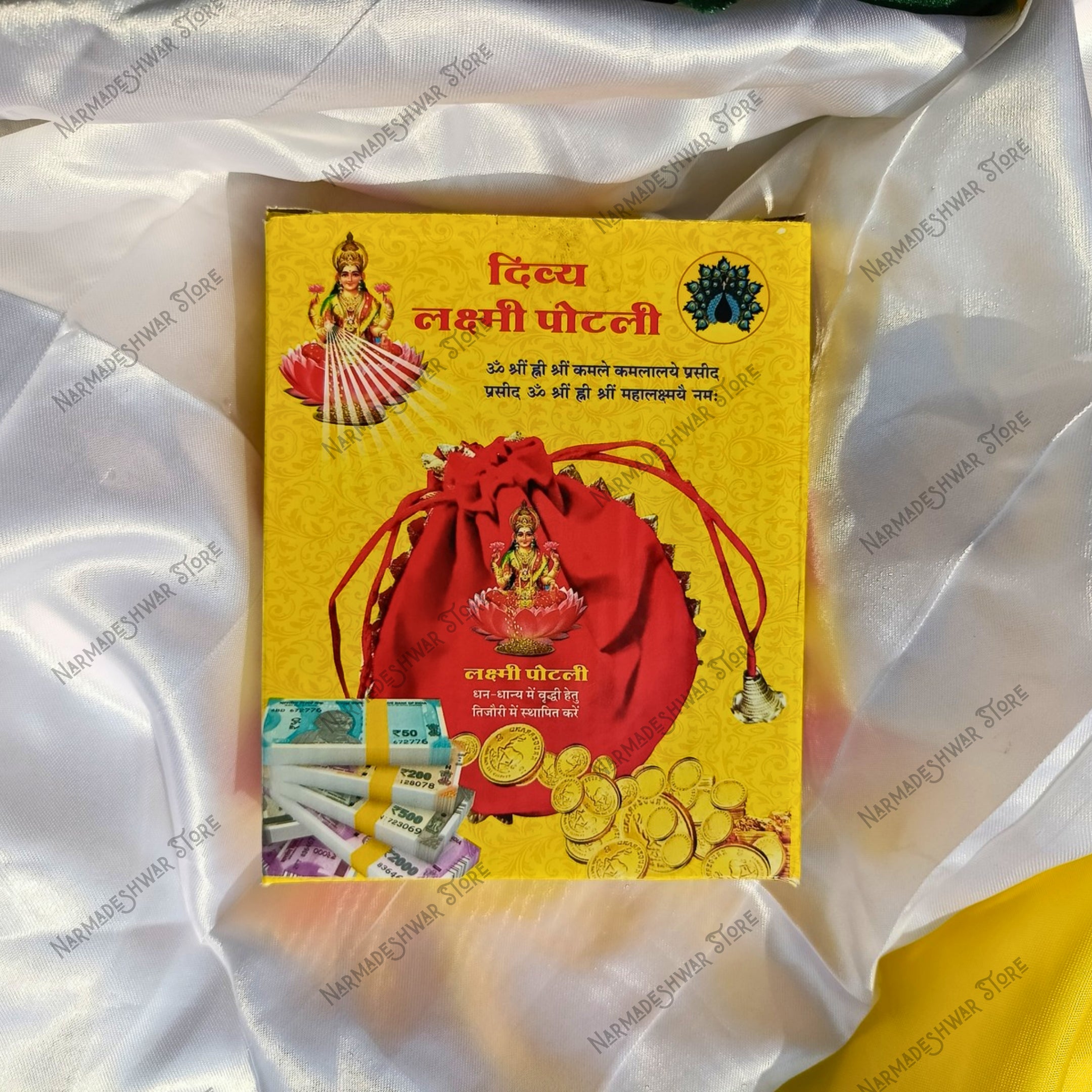 Divya Lakshmi Potli Box it has a red bag picture and gold coins on a white fabric background