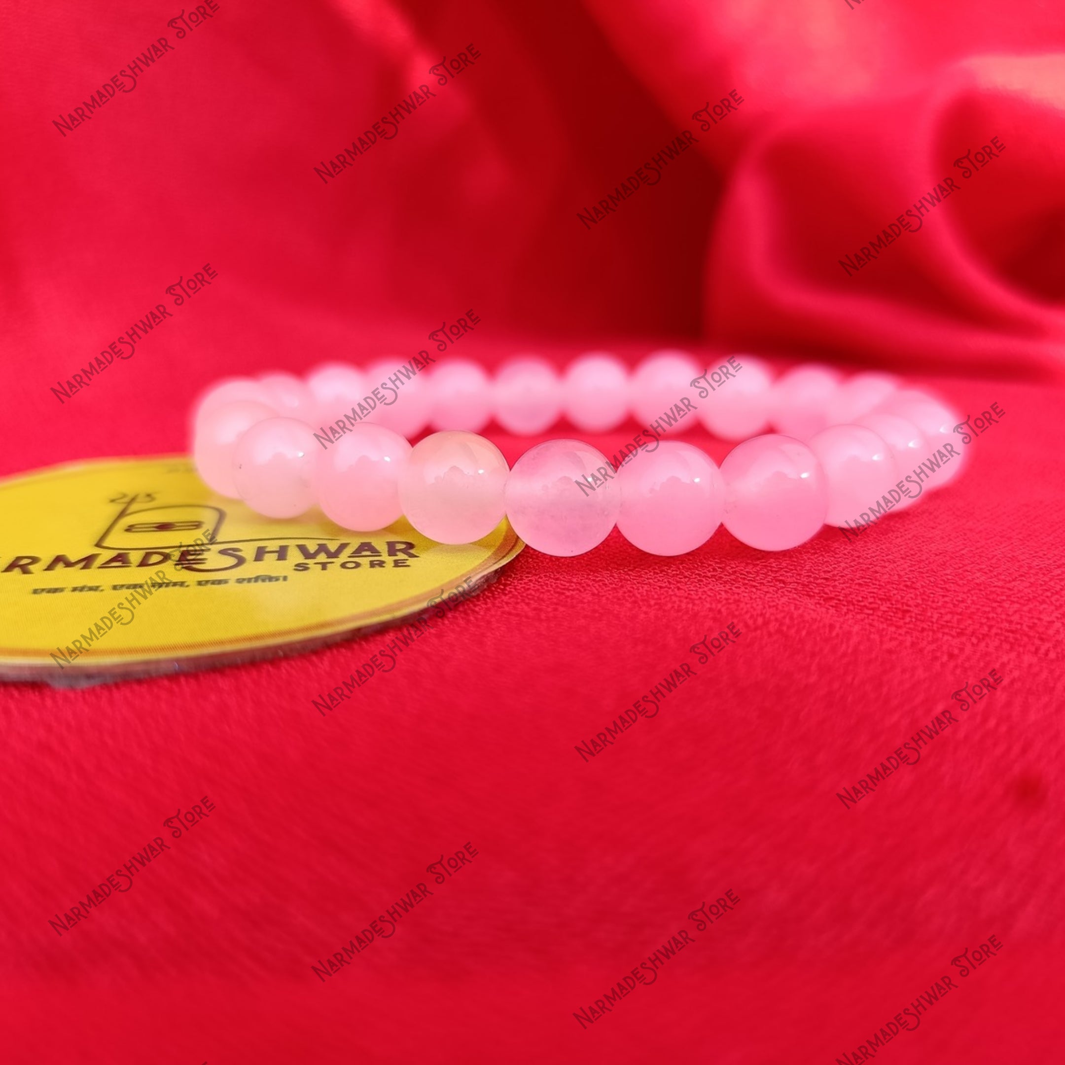 Rose Quartz healing bracelet close-up side view on red fabric background