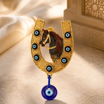Decorative horse figure in a gold horseshoe with blue eye charms on a textured beige background